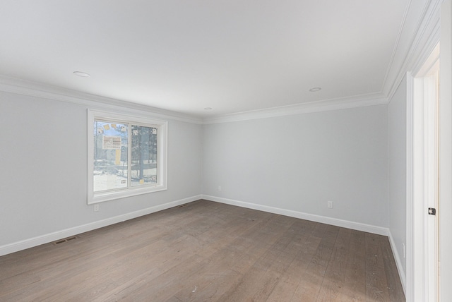 empty room with hardwood / wood-style flooring and ornamental molding