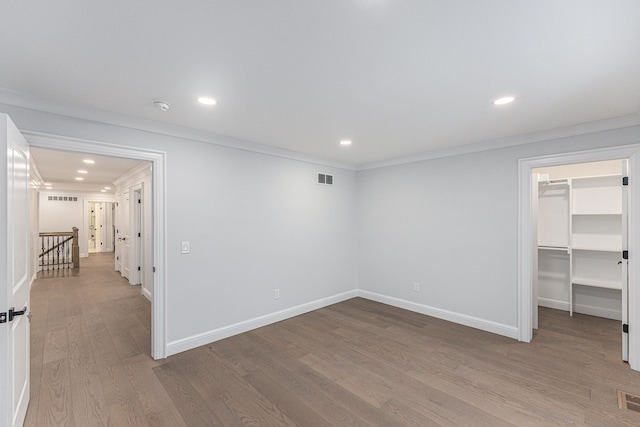 empty room featuring ornamental molding and light wood-type flooring