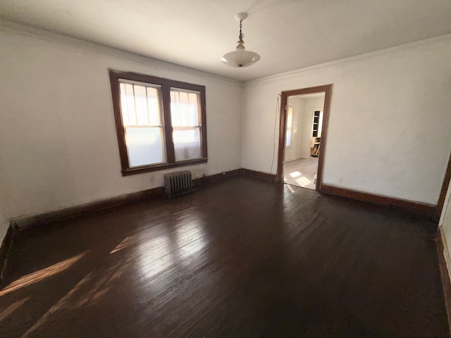 empty room featuring radiator heating unit, ornamental molding, and dark hardwood / wood-style floors