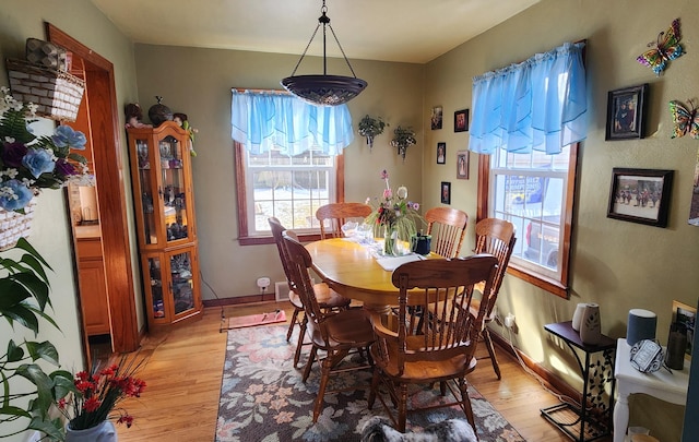dining area with baseboards and light wood-style floors