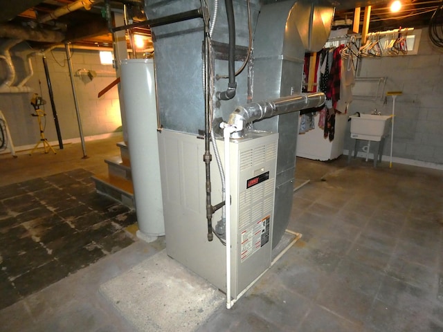 utility room with water heater and a sink