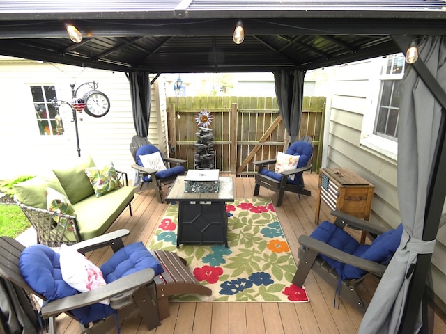 deck featuring an outdoor living space with a fire pit, fence, and a gazebo