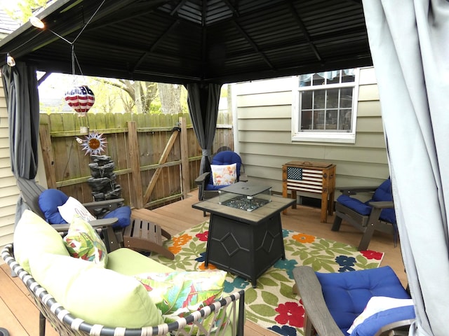 wooden terrace with an outdoor fire pit, a gazebo, and fence