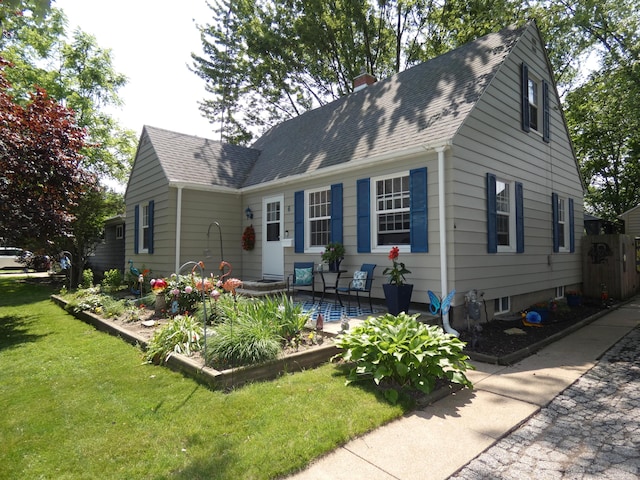 6 Poplar St, Three Oaks, MI 49128 - view of front of house featuring a front yard, a chimney, and roof with shingles