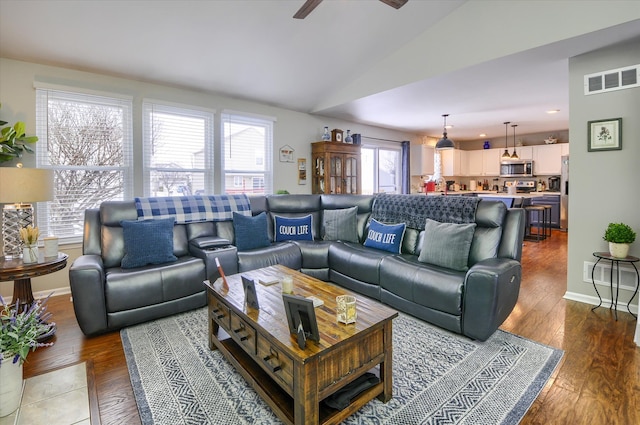 living room featuring hardwood / wood-style flooring, ceiling fan, and vaulted ceiling