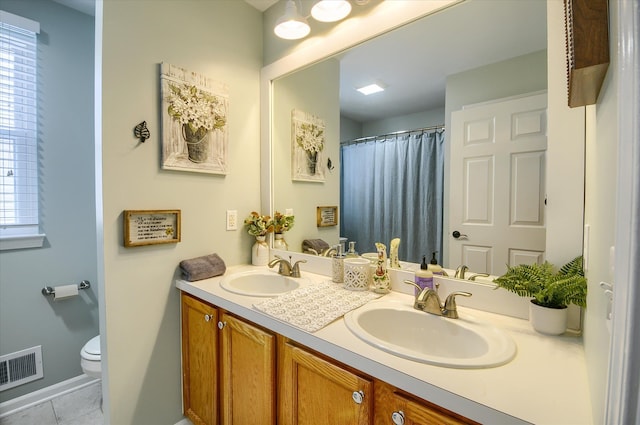 bathroom featuring vanity, tile patterned floors, toilet, and a healthy amount of sunlight