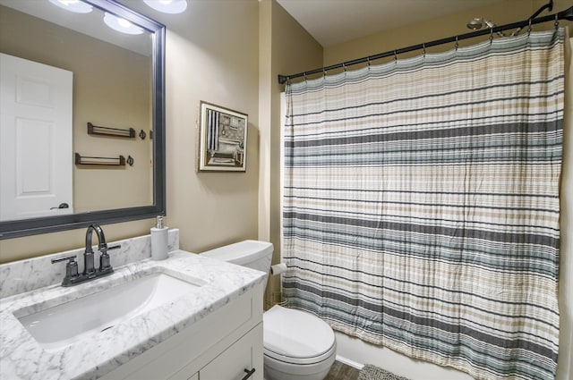 bathroom with walk in shower, vanity, and toilet