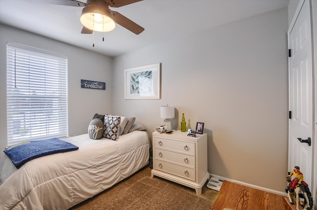 carpeted bedroom featuring multiple windows and ceiling fan