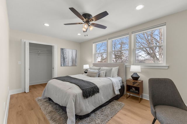 bedroom with multiple windows, a closet, ceiling fan, and light wood-type flooring