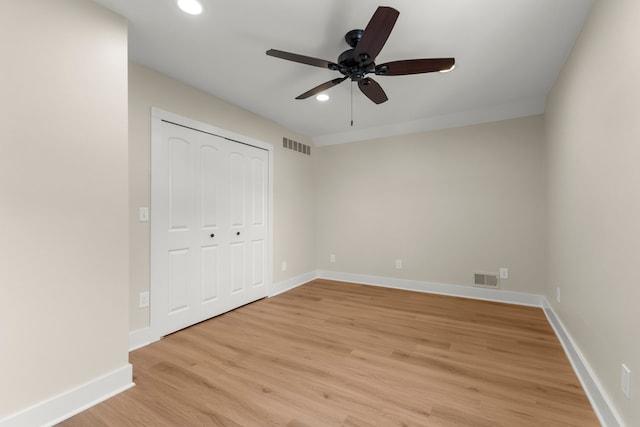 unfurnished bedroom featuring light hardwood / wood-style floors, a closet, and ceiling fan