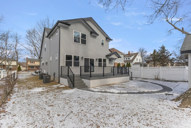 snow covered rear of property featuring central air condition unit