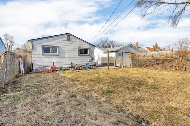 rear view of property featuring a lawn