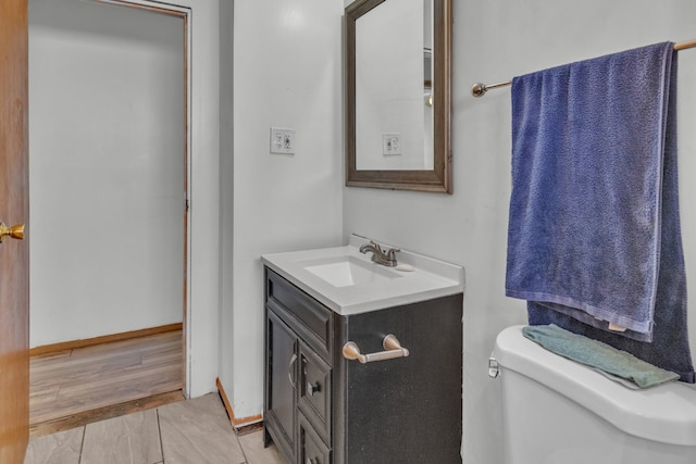 bathroom featuring vanity, hardwood / wood-style floors, and toilet