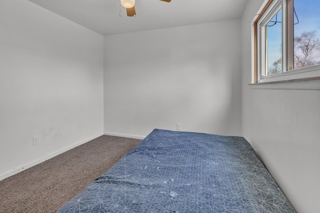 spare room featuring dark carpet and ceiling fan