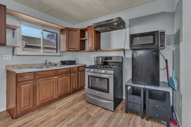 kitchen with stainless steel range with gas cooktop, sink, exhaust hood, and light hardwood / wood-style floors