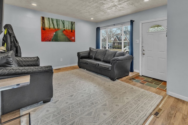 living room featuring wood-type flooring and a textured ceiling