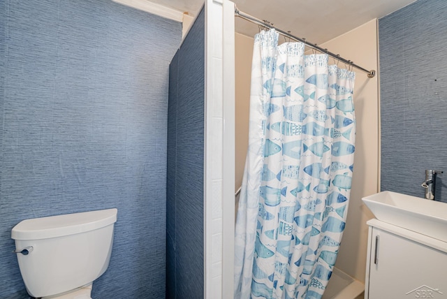 bathroom with toilet, sink, and a shower with curtain