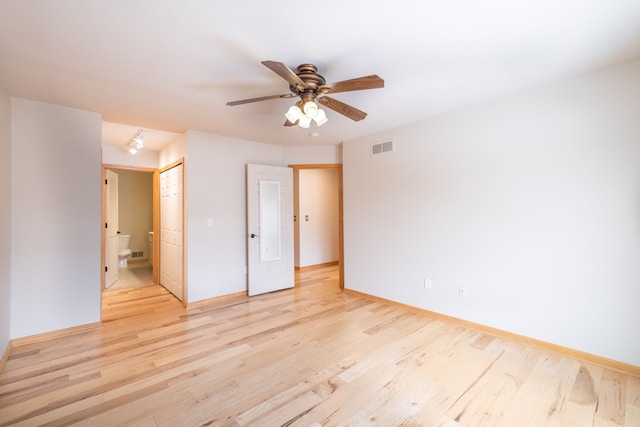 unfurnished bedroom featuring ceiling fan, a closet, ensuite bathroom, and light hardwood / wood-style flooring