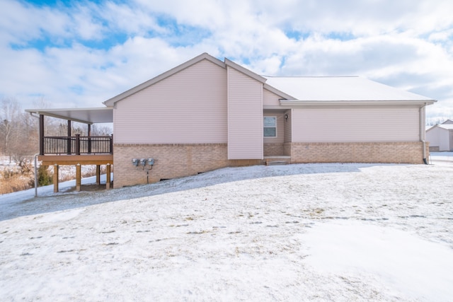 snow covered property with a deck