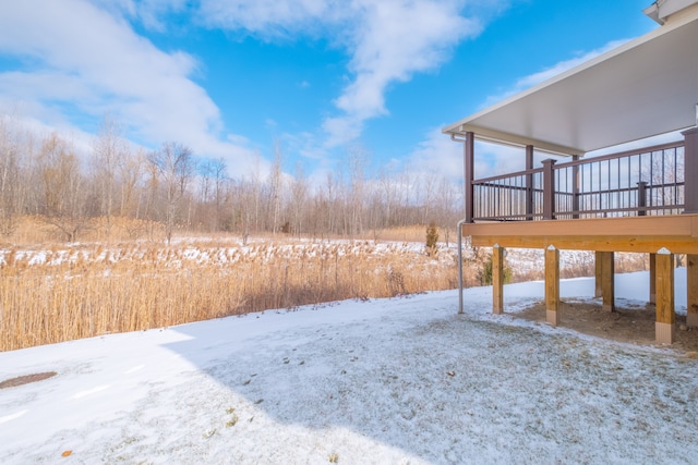 yard layered in snow with a wooden deck