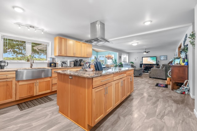 kitchen featuring sink, island range hood, a center island, and a healthy amount of sunlight