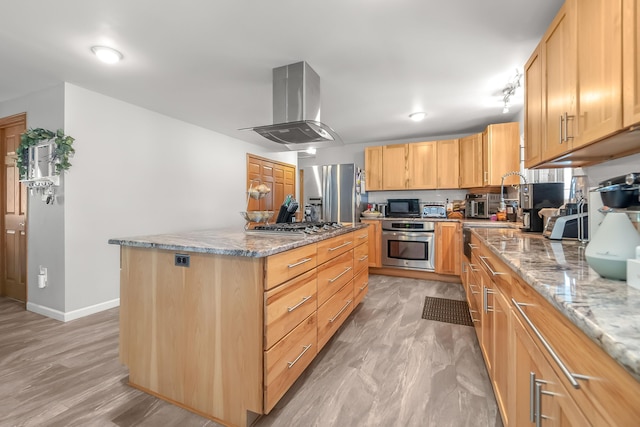 kitchen with a kitchen island, appliances with stainless steel finishes, light brown cabinetry, island exhaust hood, and light stone countertops