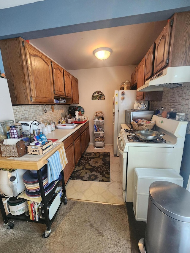 kitchen featuring sink, white range with gas stovetop, and backsplash