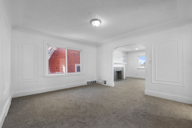 unfurnished living room featuring crown molding, carpet floors, and a textured ceiling