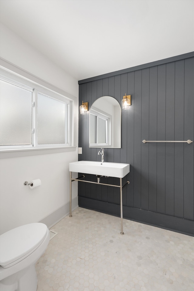 bathroom with a healthy amount of sunlight, sink, and toilet