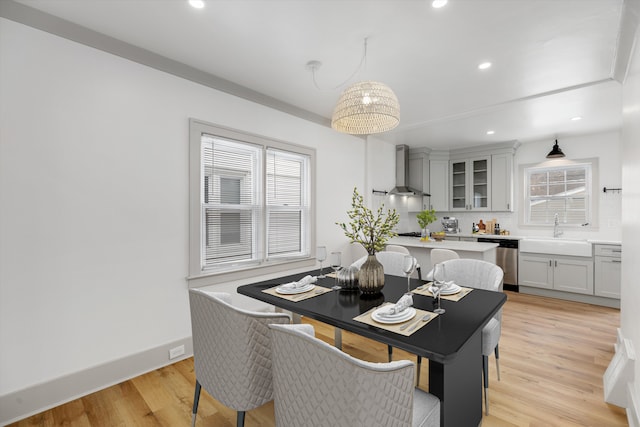 dining space with plenty of natural light, light hardwood / wood-style floors, and sink