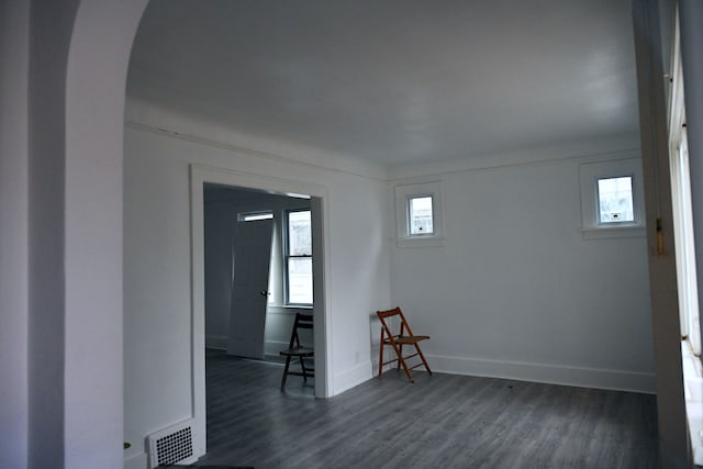 empty room with a healthy amount of sunlight and dark hardwood / wood-style floors