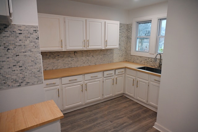 kitchen featuring dark wood-type flooring, sink, decorative backsplash, and white cabinets