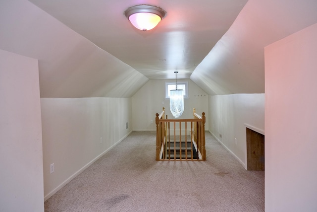 additional living space featuring lofted ceiling and light colored carpet