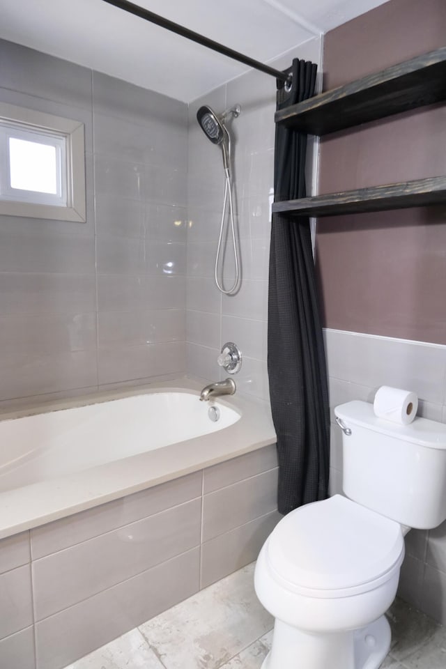 bathroom featuring tile walls, shower / bath combination with curtain, and toilet