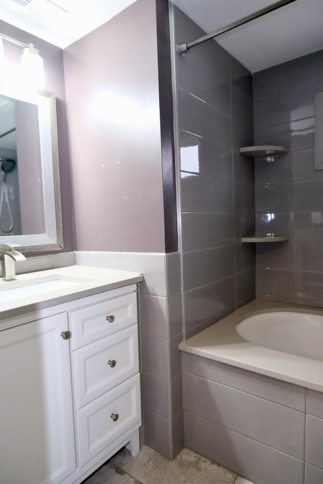 bathroom featuring vanity and tile walls