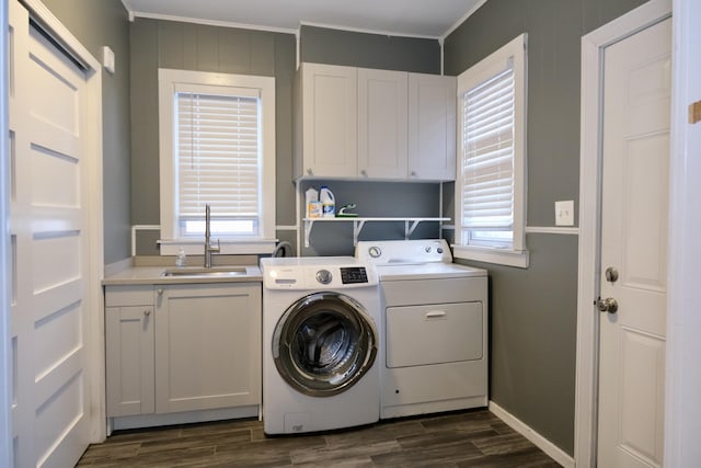 laundry area featuring cabinets, washing machine and clothes dryer, dark hardwood / wood-style floors, and sink