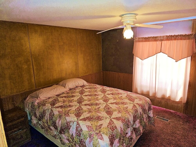 bedroom with wooden walls and ceiling fan