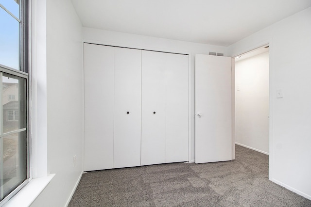 unfurnished bedroom with carpet floors and a closet