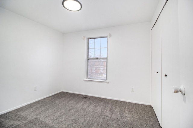 interior space featuring dark carpet and a closet