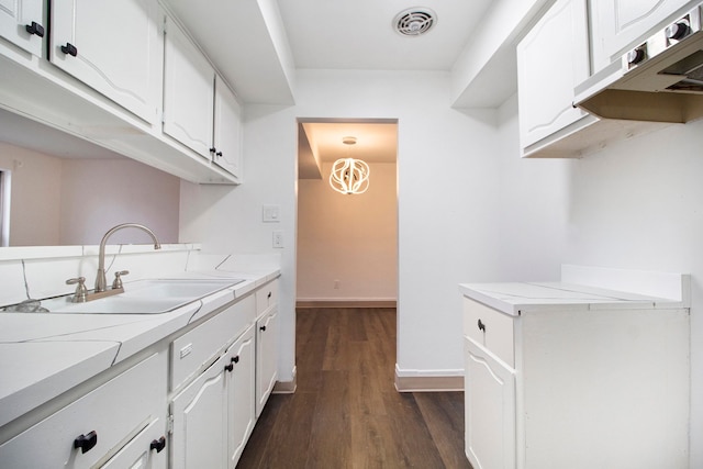 kitchen featuring dark hardwood / wood-style floors, sink, and white cabinets