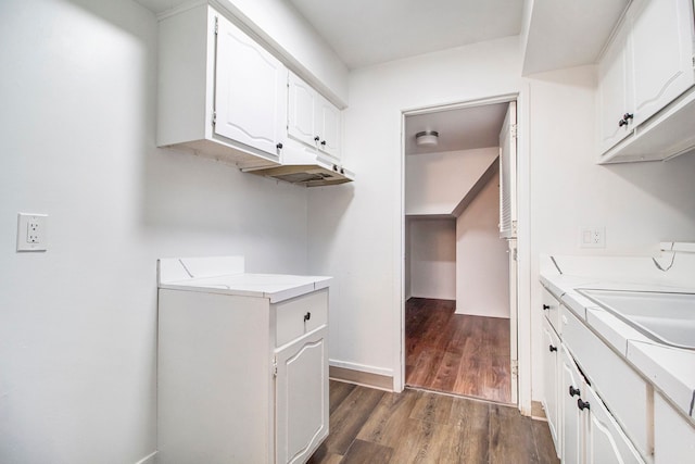 clothes washing area with dark hardwood / wood-style flooring, sink, and cabinets