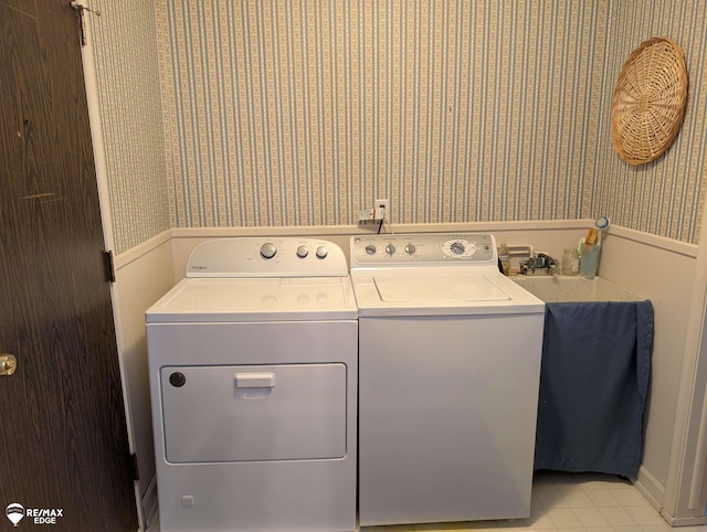 laundry room with light tile patterned flooring and washer and clothes dryer