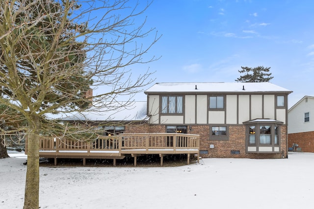 snow covered house featuring a wooden deck