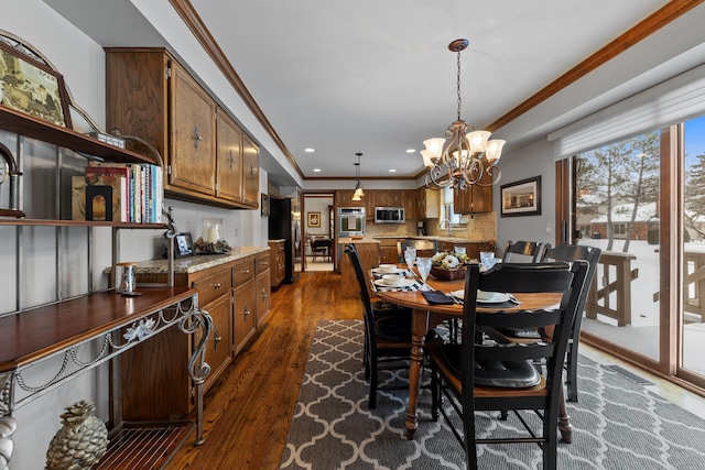 dining area with crown molding, dark hardwood / wood-style floors, and a notable chandelier