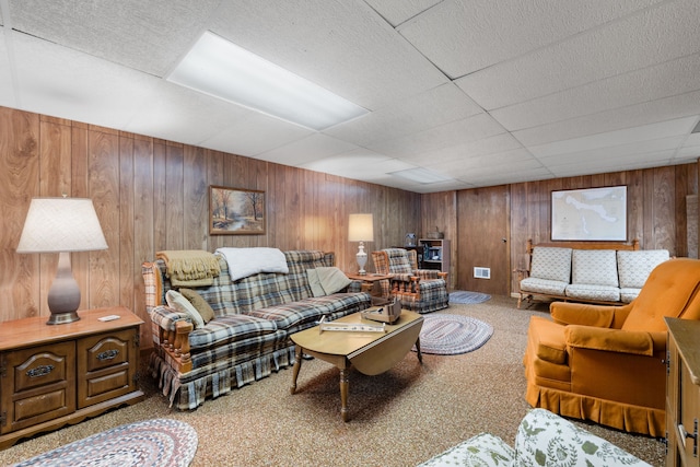 carpeted living room featuring wood walls