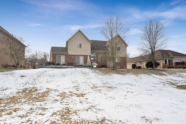 view of snow covered back of property