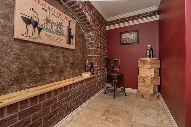 wine room with crown molding and brick wall