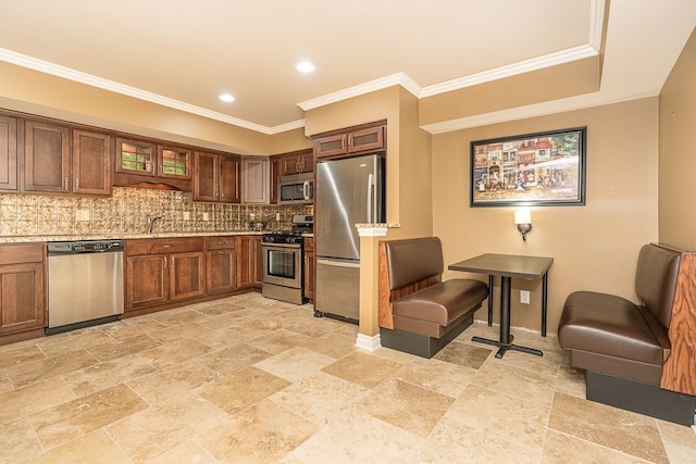 kitchen with sink, crown molding, stainless steel appliances, tasteful backsplash, and light stone counters