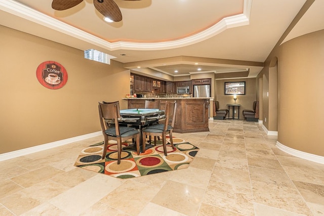 dining space with bar, crown molding, a raised ceiling, and ceiling fan