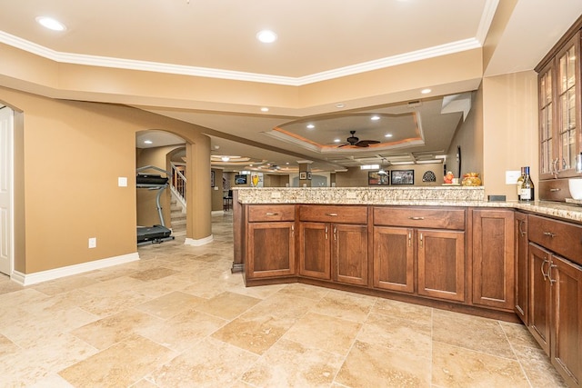 kitchen featuring ornamental molding, kitchen peninsula, and a tray ceiling